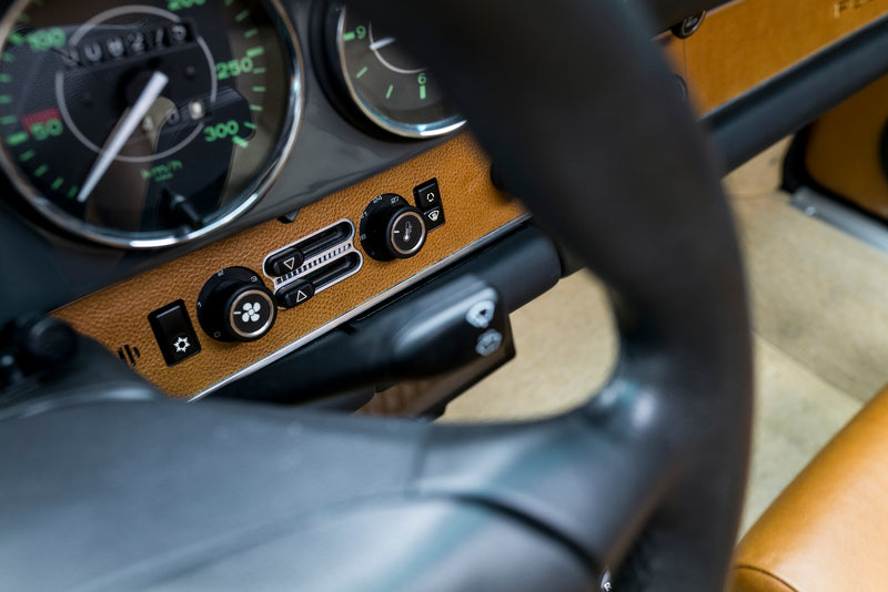 Close-up of a Triebwerk F3.6 steering wheel and dashboard with a focus on the controls.