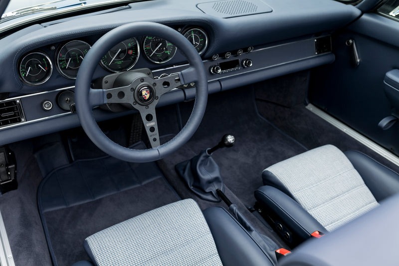 Blue Triebwerk F3.8 Targa interior with steering wheel and dashboard in a vintage design.