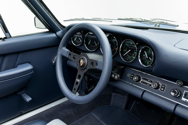 Blue Triebwerk F3.8 Targa interior with steering wheel and dashboard on a white background
