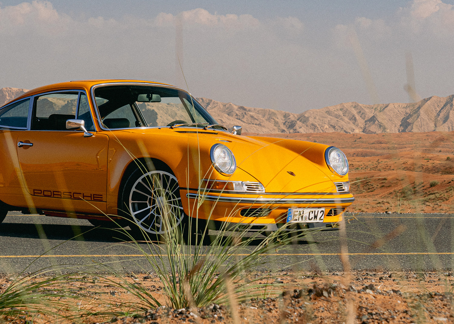 Yellow Triebwerk F4.3 Porsche 911 on a road with a desert landscape