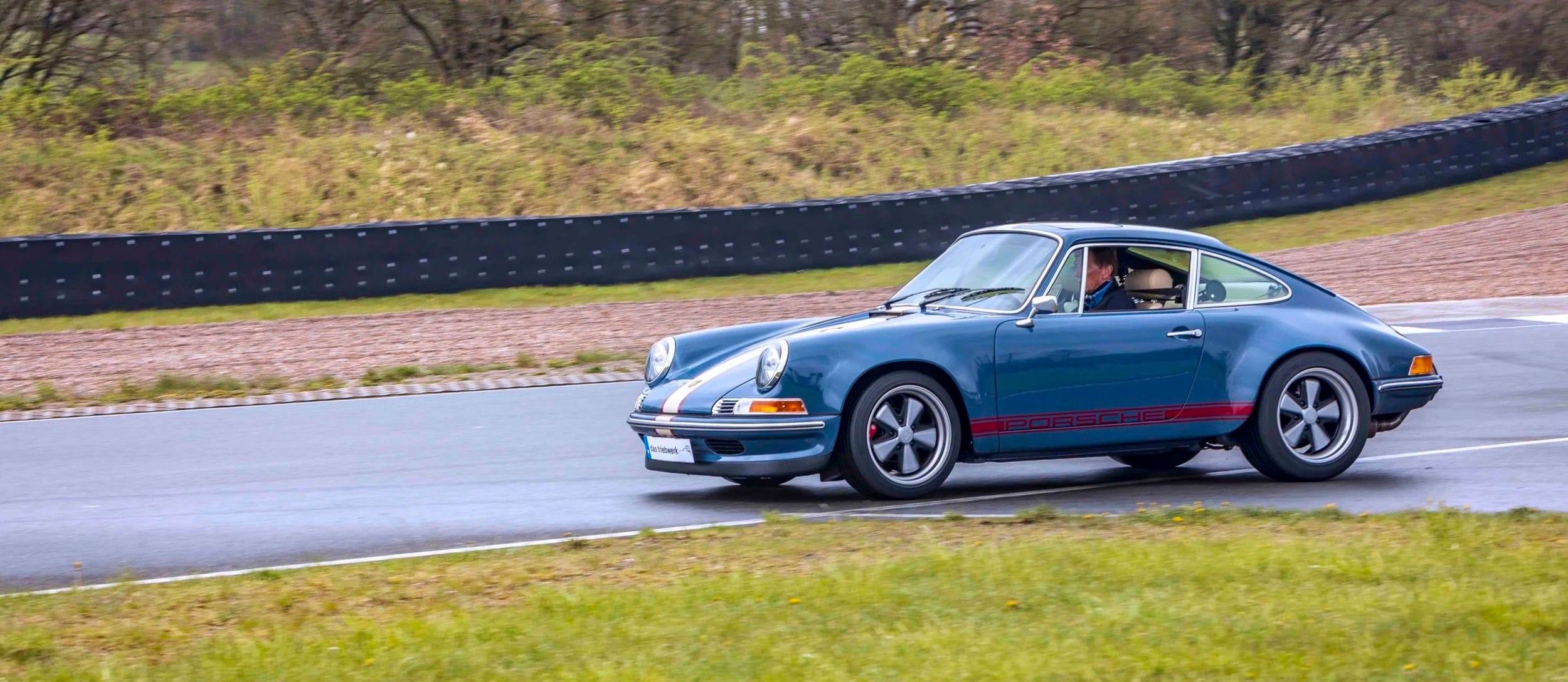 Blue Triebwerk F350 Porsche 911 on a track with a blurred background