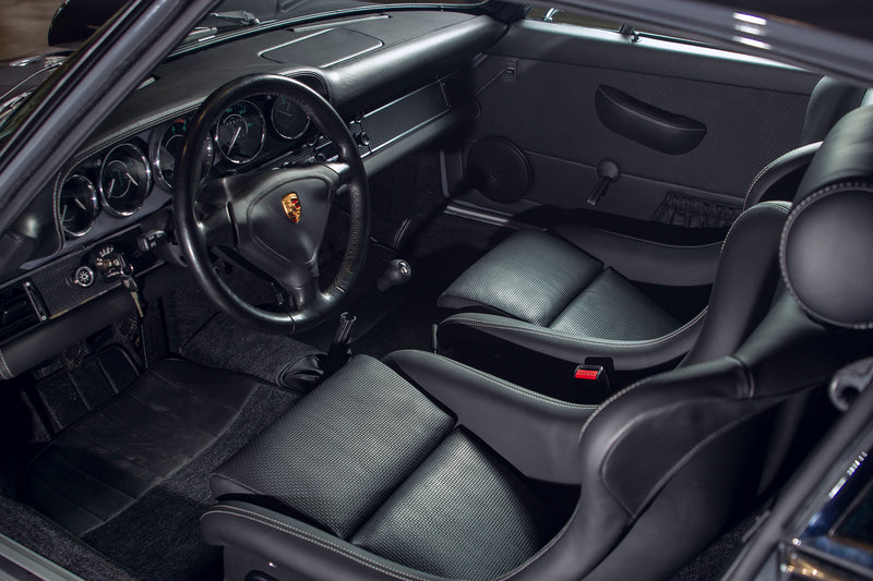 Triebwerk F3.8 black interior with steering wheel and dashboard, featuring a Porsche logo.