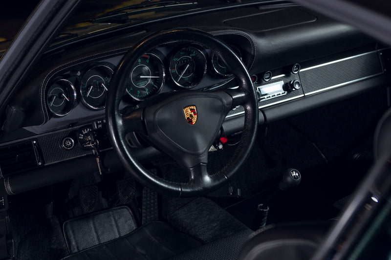 Steering wheel with Porsche logo in a Triebwerk F3.8 interior