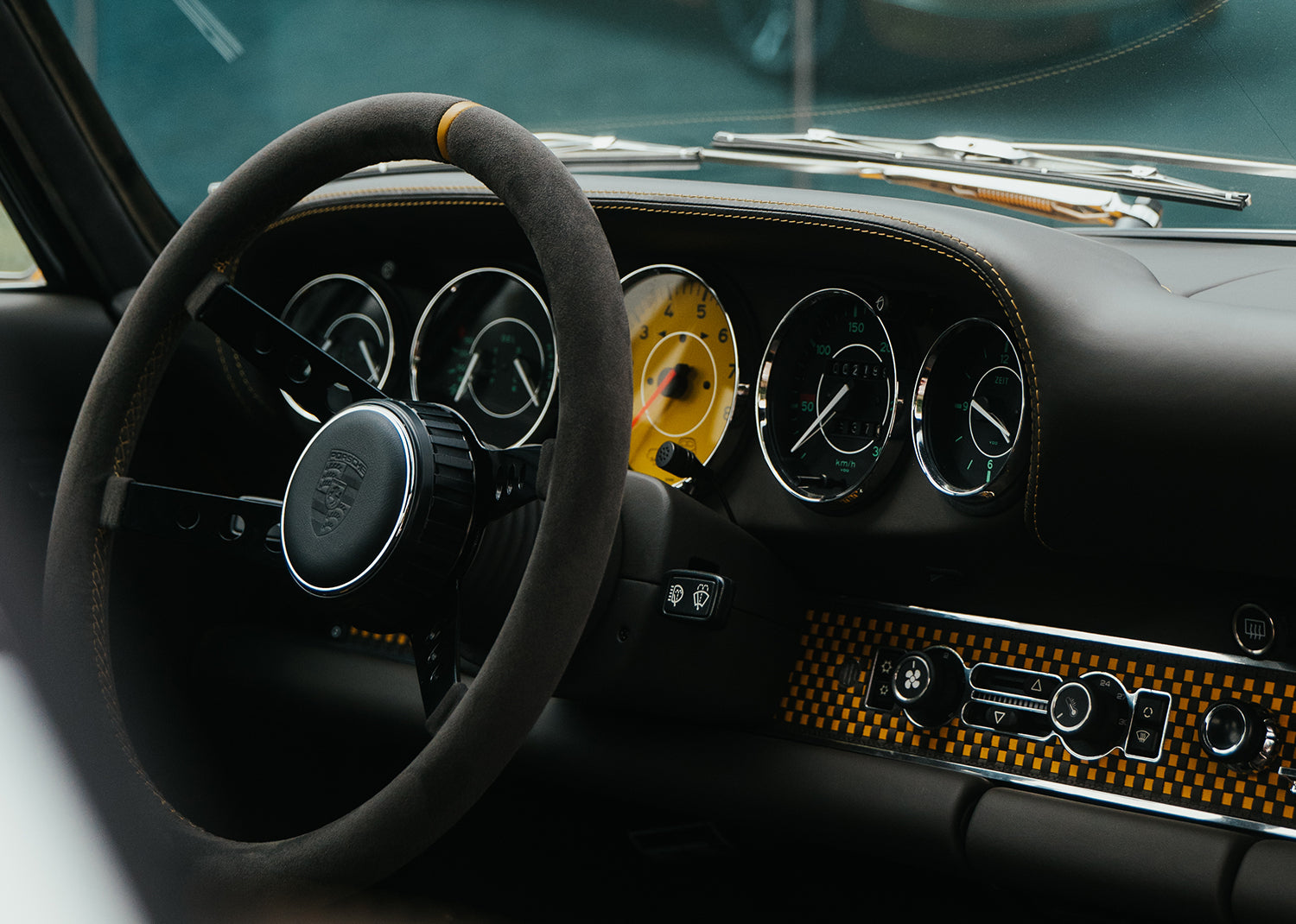 Yellow Triebwerk F4.3 Porsche 911 interior with steering wheel and dashboard in a close-up shot