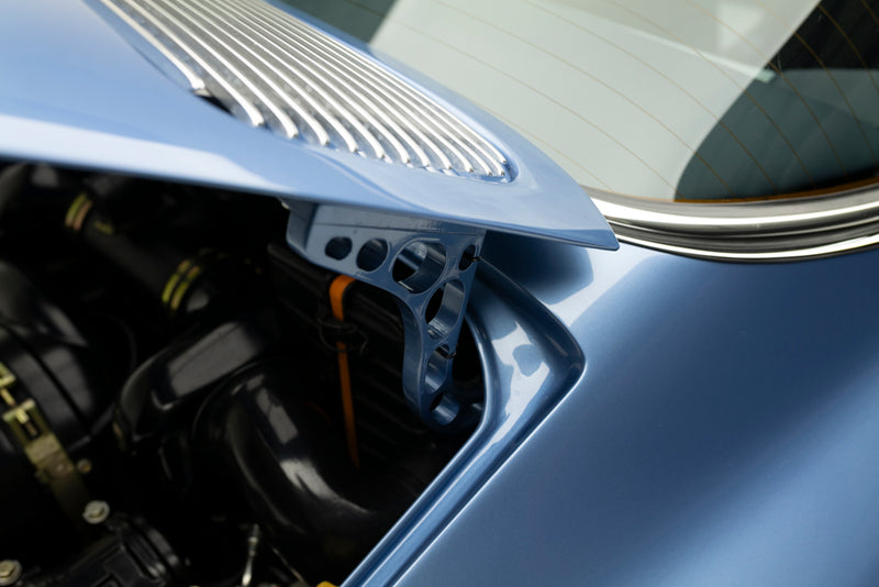 Close-up of a Blue Triebwerk F3.8 Targa's engine cover hinge with a focus on the metallic finish.