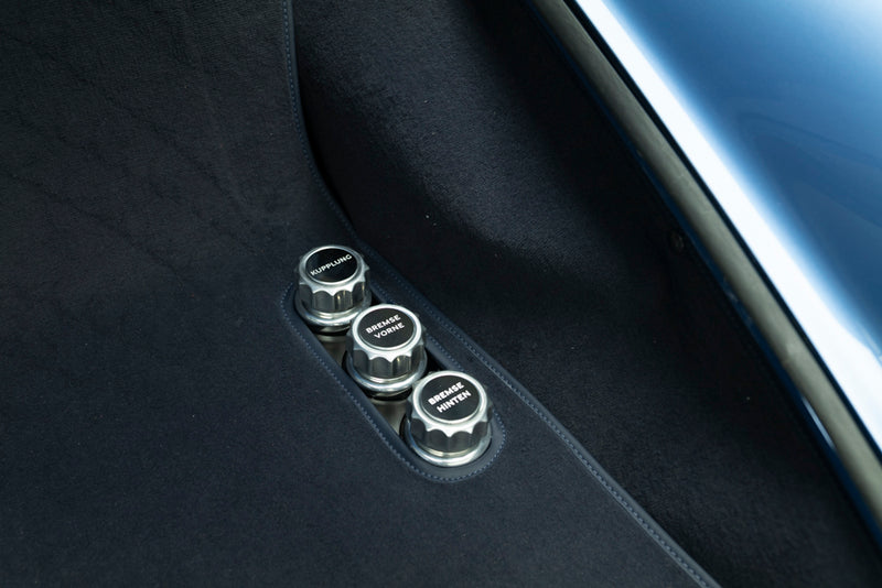 Close-up of three metallic dial knobs on inside frunk of Blue Triebwerk F3.8 Targa.